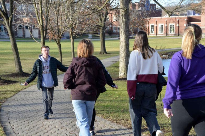 A male student leads a tour of campus